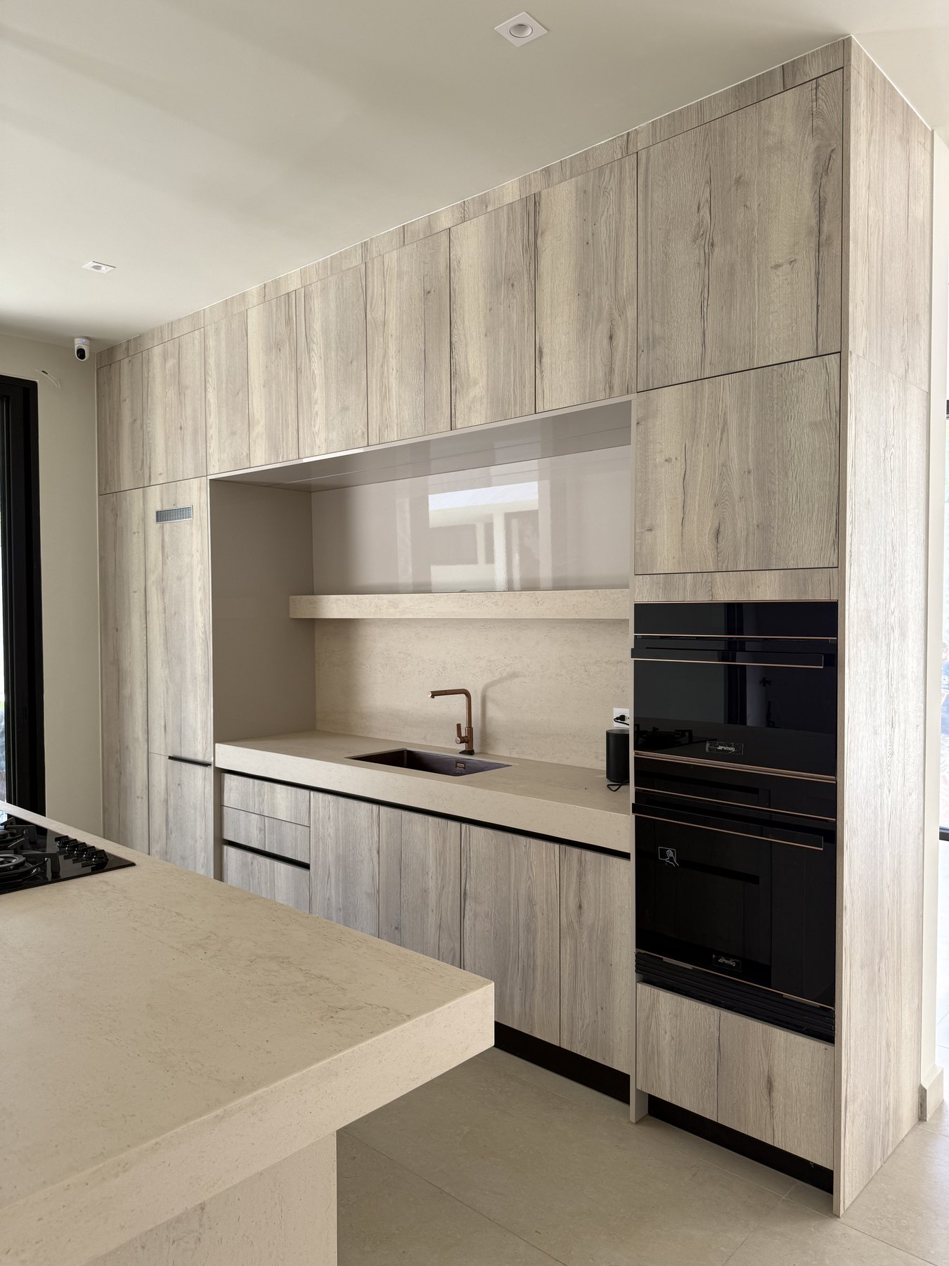Cocina Novecci gris con mobiliario integrado y electrodomésticos empotrados