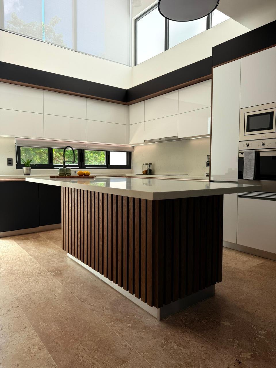Cocina Novecci de doble altura con isla de madera acanalada